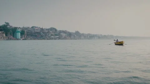 Fisherman rowing a boat on the Ganges river in Varanasi, India Stockbeeldmateriaal 333144608