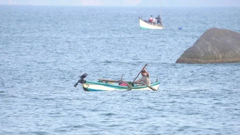 Fisherman Rowing Small Boat on Calm Sea Wide Shot with Copy Space Stock Footage 331704576