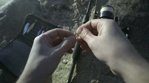 Fisherman selecting and stringing a lure on the shore of the sea. POV shot. Stock Footage 239893308