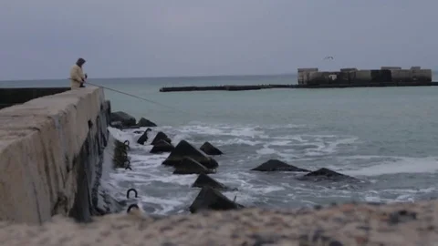 A fisherman sets up on the beach Video stock 78484944