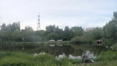 Fisherman on the shore of the pond timelapse Stock Footage 77284289
