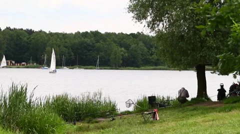 Fisherman sitting by a lake Stockbeeldmateriaal 40675965