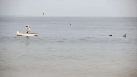 Fisherman on a small boat casts a net Vídeo Stock 115620002