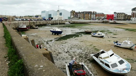 Fisherman sorting nets in the foreground, Margate Harbour Arm Stock Footage 67578607