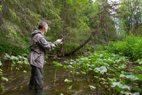 Fisherman with a spinning performs retrieval Stock Photos