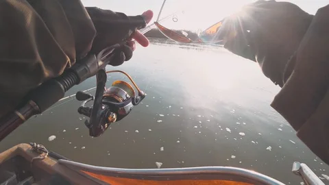 Fisherman spinning a powerful predatory fish from a boat at sunset Stock Footage 127799078