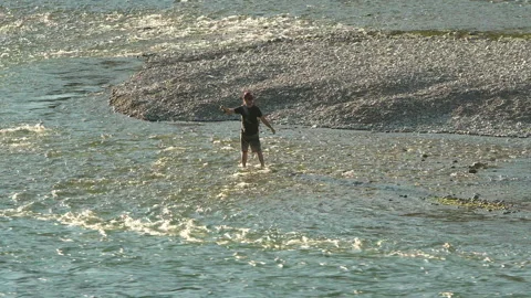Fisherman is standing in a mountain river fly fishing. Stock Footage 214533532
