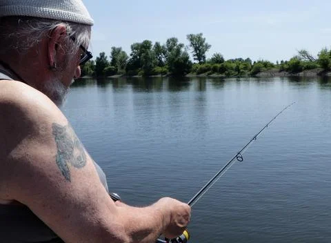 Fisherman standing at the river Stock Photos