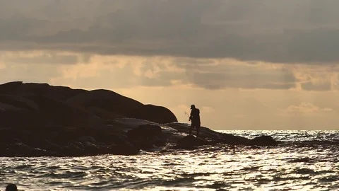 Fisherman on sunset ocean background in slow motion Stock Footage 84188919