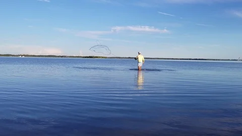 Fisherman throwing cast net standing in shallow water Stock Footage 94668367