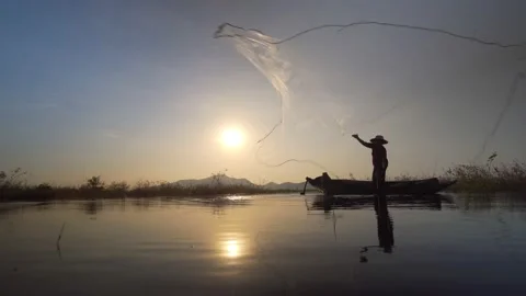Asian Fisherman Throwing a Net for Catching Freshwater Fish in the