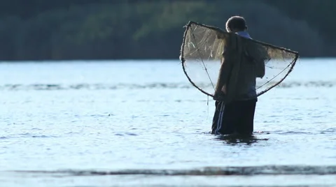 Fisherman throwing his fishing net at lake. Fisherman fishing fish. Stock Footage 54237053