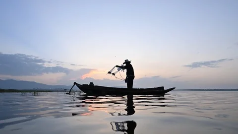 Fisherman throwing net into the lake Stock Footage