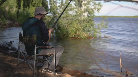 Fisherman throws a hook into the river and carefully monitors Stock Footage 133163058