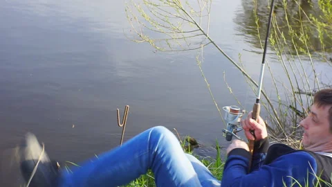 Fisherman turns the coil to pull the fish. Stock Footage 107324341