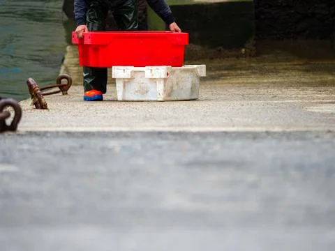 Fisherman unloading boxes of fish in a port of a village in the Basque countr Stock Photos
