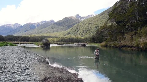 Fisherman wading and casting in a river. Fiordland National Park, New Zealand. Stock Footage 134990314