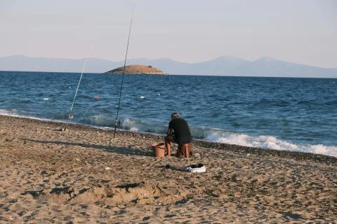 Fisherman waiting for fishes by the sea Stock Photos