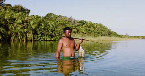 Fisherman walking with his fish catch of the day from an traditional fish trap Stock Footage 290489591