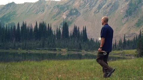 Fisherman Walking with Mountains in Background Stock Footage 84036169