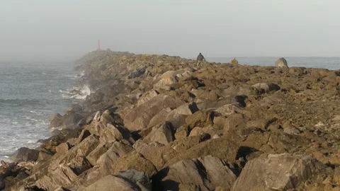 A fisherman walks down the jetty Video stock 305098577