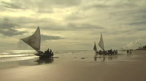 Fisherman working together to get their sail boats out to sea Stockbeeldmateriaal 19182202