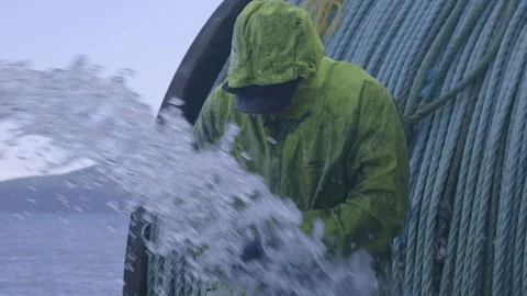 Fisherman in yellow rubber jacket showering and cleaning himself on fishing boat Stock Footage 138891900
