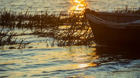 Fisherman's boat in the rays of the setting sun Stock Photos