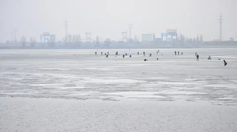Fishermen angling on ice on background of electric power station Stock Footage 49626071