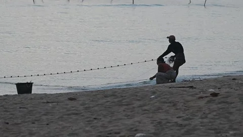 Fishermen are dragging their nets to catch fish on the coast. Видео 131602686