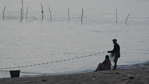 Fishermen are dragging their nets to catch fish on the coast. Видео 131602850