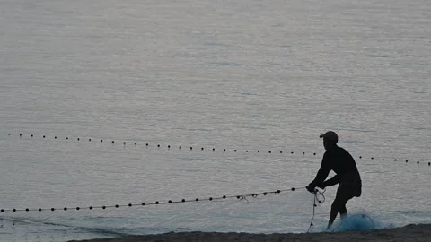 Fishermen are dragging their nets to catch fish on the coast. Видео 131603015