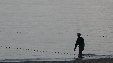 Fishermen are dragging their nets to catch fish on the coast. Видео 131603202