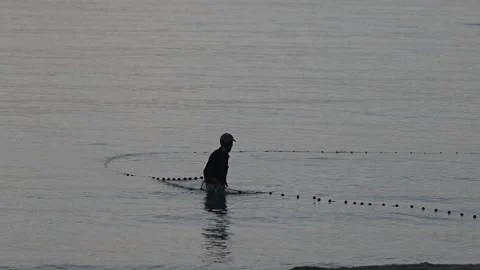 Fishermen are dragging their nets to catch fish on the coast. Видео 131603374