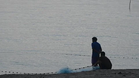 Fishermen are dragging their nets to catch fish on the coast. Видео 131603872