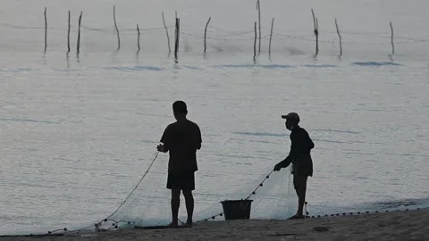 Fishermen are dragging their nets to catch fish on the coast. Видео 131603949