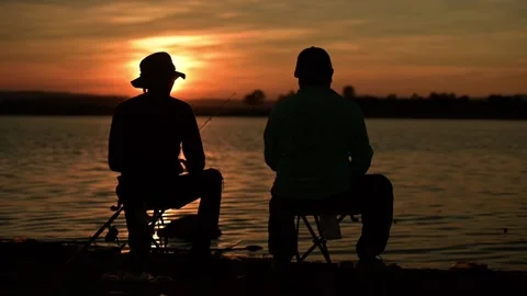 The fishermen are sitting and drinking water while fishing Silhouette sunset. Stock Footage 133207409