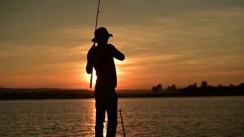 Fishermen are using fishing rods in the reservoir during Silhouette sunset. Stock-Footage 133207449