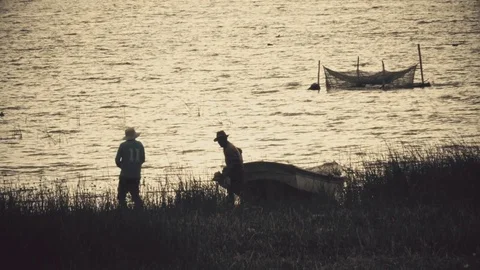 Fishermen on beach at sunset Stock Footage 80693078