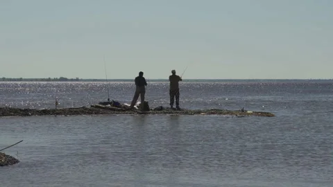 Fishermen catch fish on the river spit. The bay. Overall plan Stock Footage 137377090