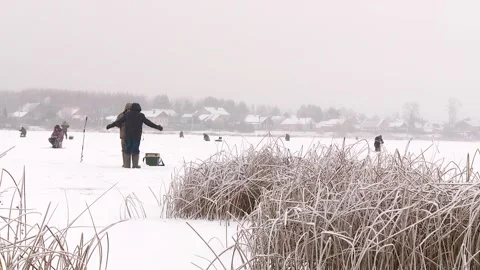 Fishermen catch fish in winter on river ice Stock Footage 246424547