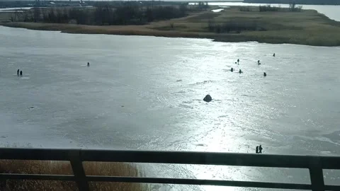 Fishermen catching fish on the river in winter, fishing on the open ice, winter Stock Footage 235157559