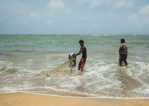 Fishermen cleaning nets Stock Photos