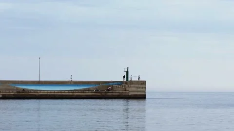 Fishermen on a concrete pier trying to catch fish Stock Footage 62242955