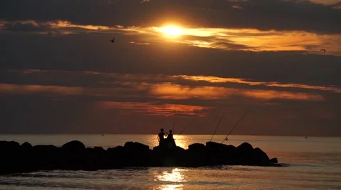 Fishermen in the evening on the coast Stock Footage 67943377