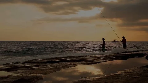 Fishermen fish on the beach at sunset Stock Footage 115860119