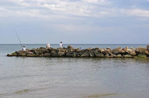 Fishermen to fish standing on the rocks Stock Photos