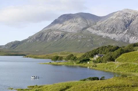 Fishermen on loch Stack beneath the peak of Arkle in Sutherland Scotland UK Foto stock