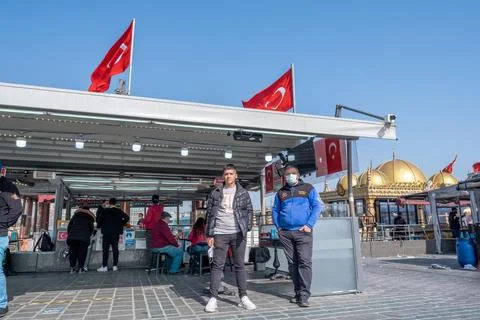 Fishermen pose for camera in front of fish restaurant selling grilled fish Stock Photos