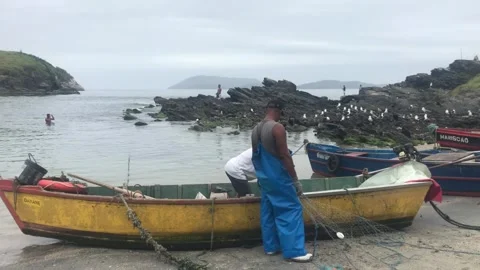 Fishermen preparing a net on a beach in Arraial Do Cabo, Brazil Stock Footage 342647839